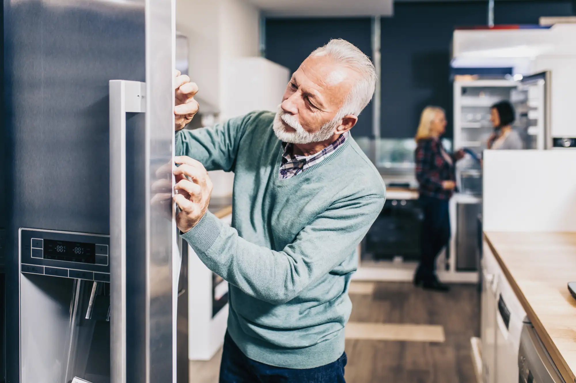 Mann prüft Maße von Side by Side Kühlschrank